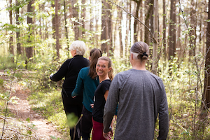 Fyra av Midagons medarbetare är ute och promenerar tillsammans på en stig i skogen.